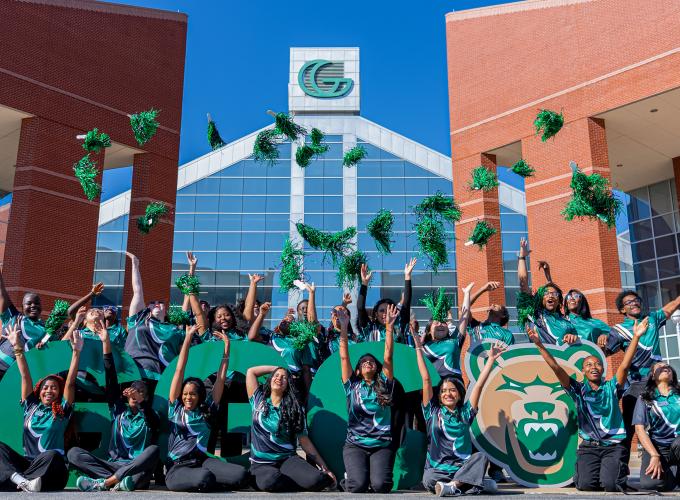 A group of Georgia Gwinnett College students posing in front of G-G-C letters and the Grizzly head