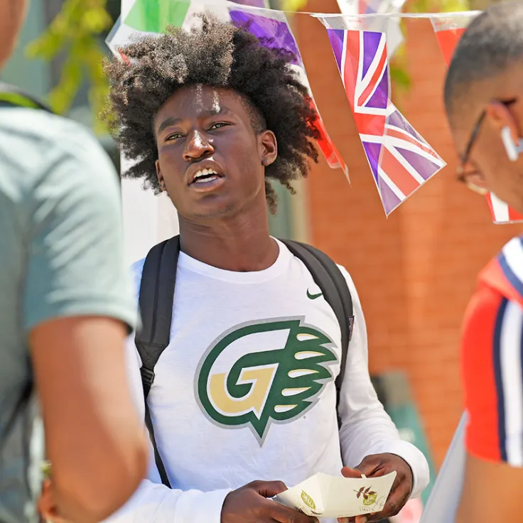 student enjoying a hot dog at the international event