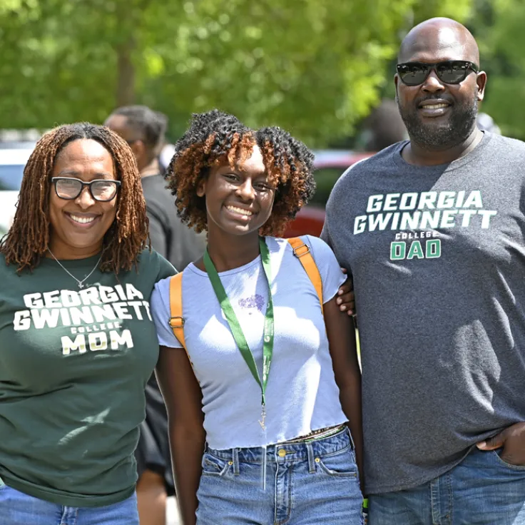 Student with parents smiling at camera