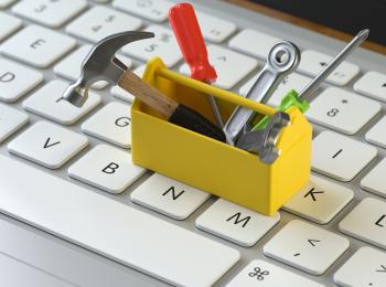 White keyboard with yellow toolbox and tools placed on top