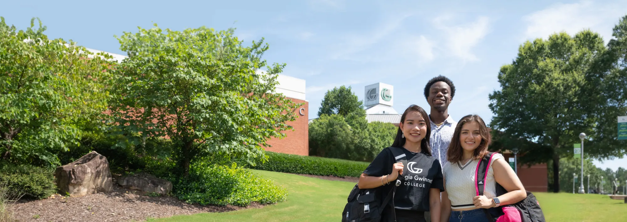 Three students smiling at the camera