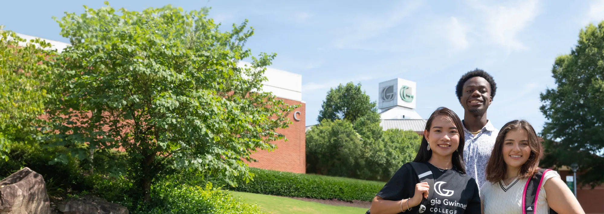 Three students smiling at the camera