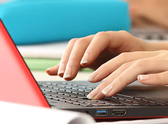 hands typing on colorful laptop