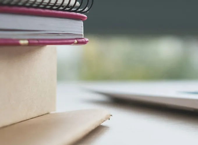 stack of books next to a laptop
