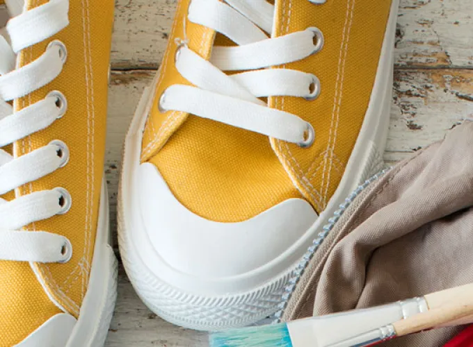 Yellow sneakers and a backpack spilling school supplies