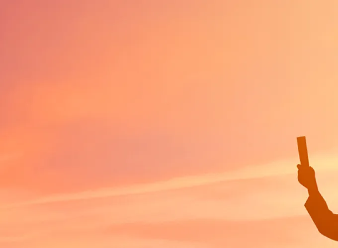 Sunset with two silhouetted graduates