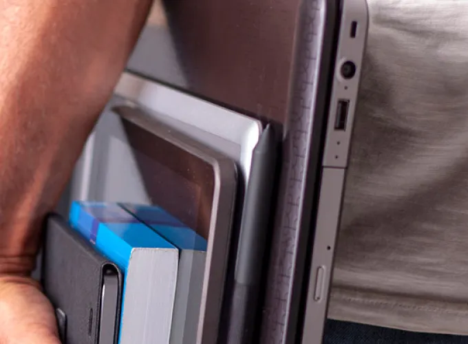 student carrying book, laptop and tablet