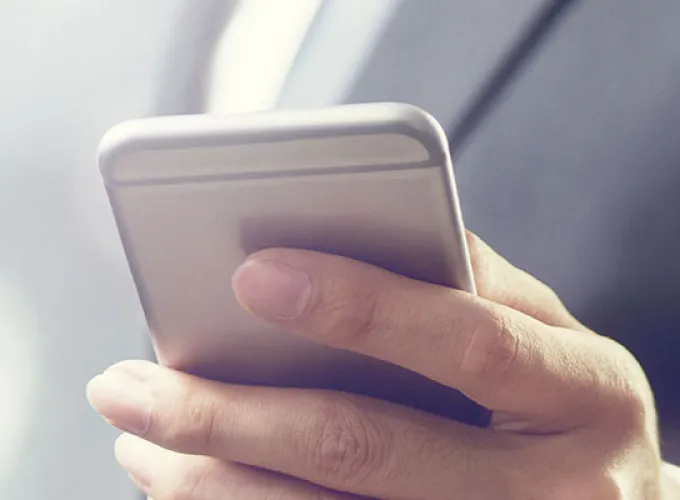person in business suit holding cell phone