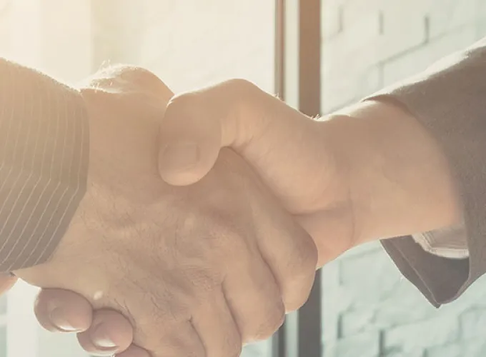 Two people in business attire shaking hands