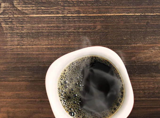 student texting while enjoying coffee