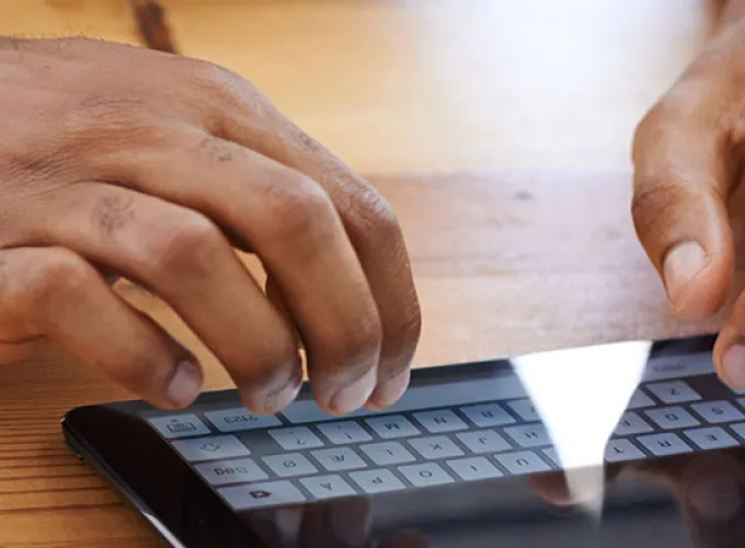 hands typing on tablet keyboard
