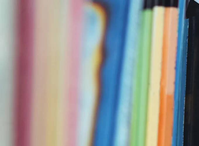 hand pulling tablet from bookshelf with books