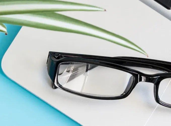 desktop with open laptop, plant and glasses