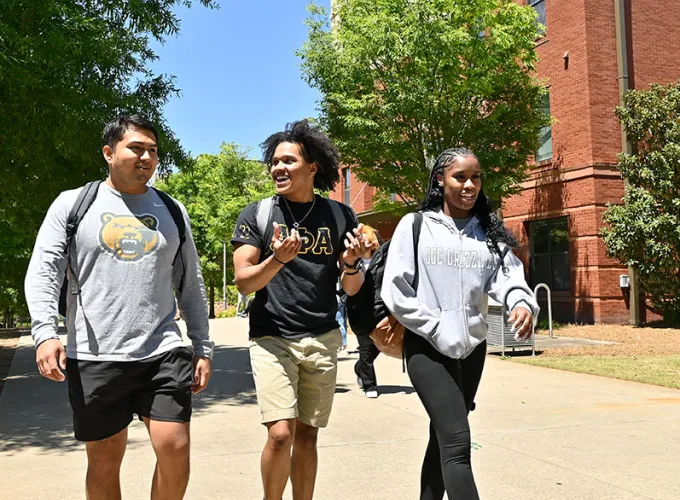 students walking near housing on a sunny day