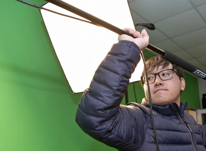 Male student holding boom mic
