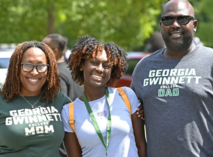 Student with parents smiling at camera