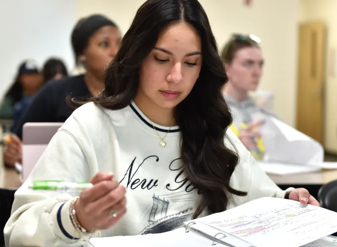 Student looking at her notes in class