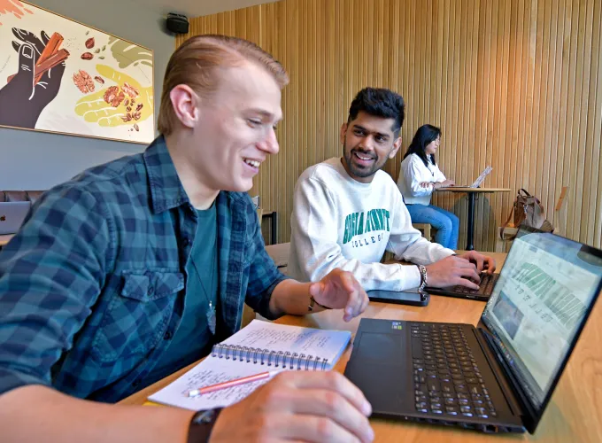 Three students looking at a laptop