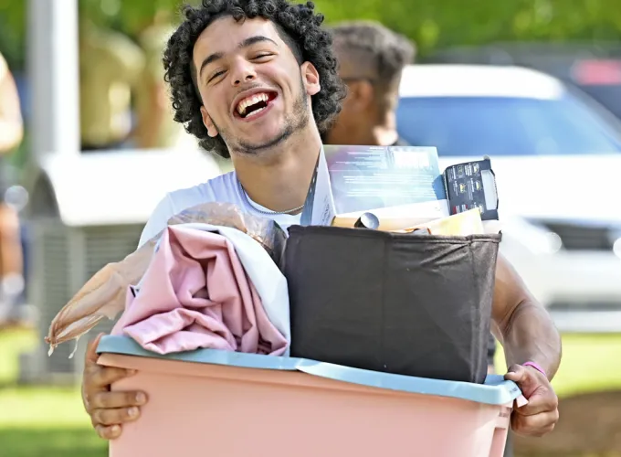 Male student holding boxes