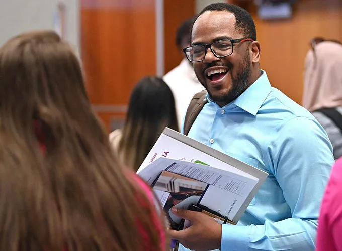 GGC student enthusiastically talking with employer at career fair