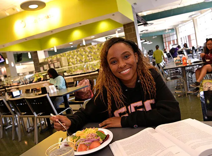 GGC student eating in the Dining Hall while studying