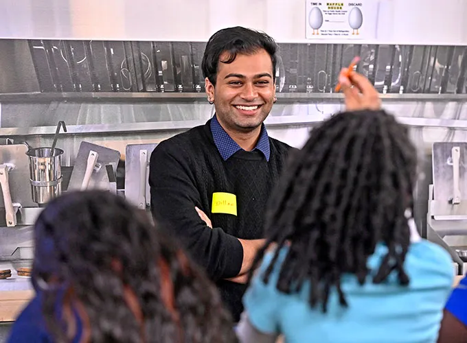 Business major speaking with Junior Achievement members during event