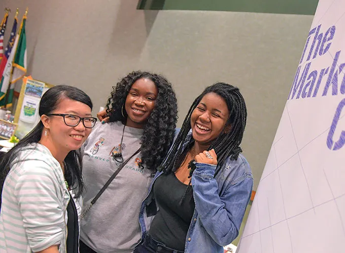 three female students at an event for the Marketing Club