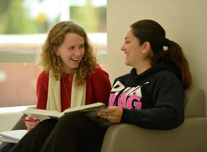 Two GGC students studying over textbook