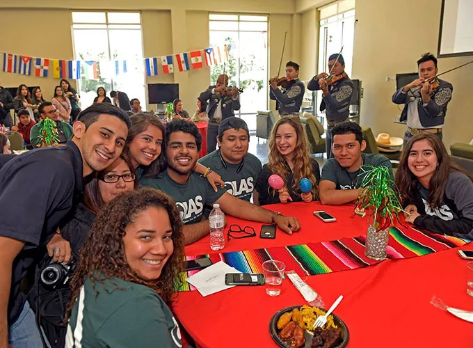 OLAS members seated at red covered table during club event
