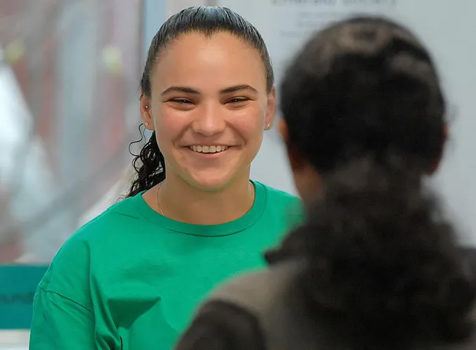Josie Nunez smiles warmly as she assists with registration during the Olifer Math Competition