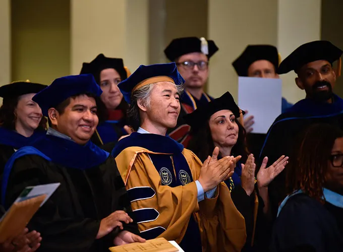 Clapping faculty audience dressed in ceremonial robes