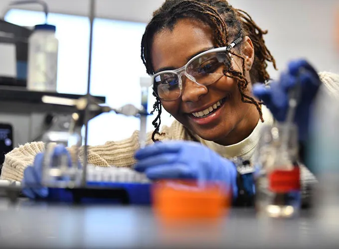 GGC female student conducting biochemistry experiment