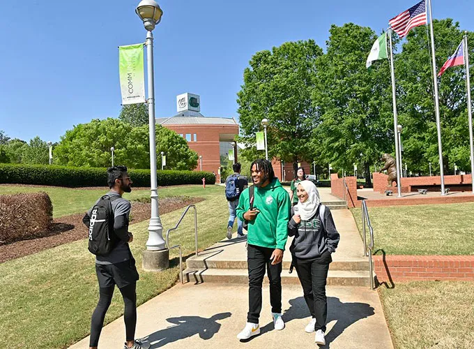 Walking students passing by near grizzly statue