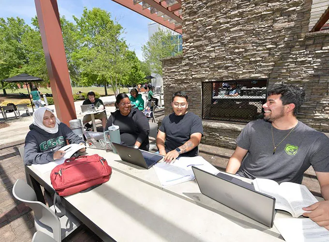 students studying in front of pergola fireplace