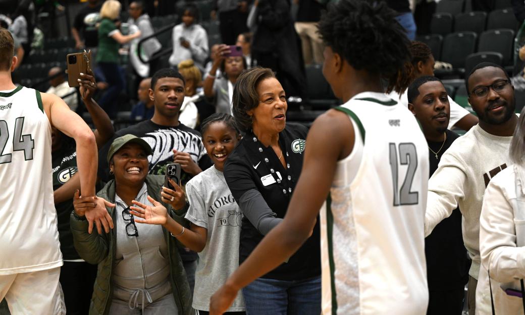 President Jann L. Joseph celebrates along with other GGC basketball fans after a winning basketball game.
