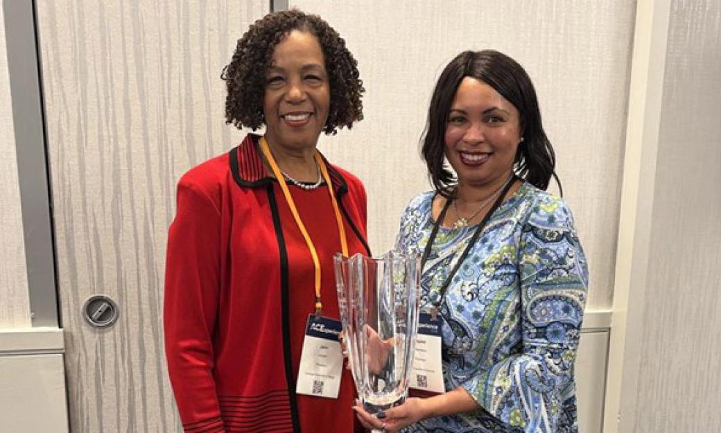 Dr. Jann L. Joseph, president of Georgia Gwinnett College and chair of the ACE Women’s Network, standing with Crystal Chambers, program chair of the North Carolina ACE Network, who is holding a glass award shaped like a vase