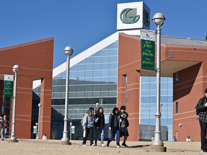 Students walking in front of Building B on campus.