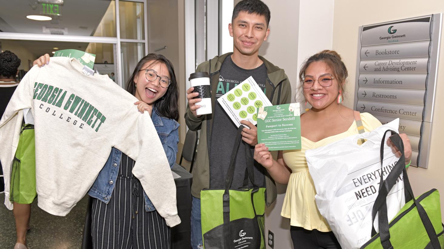 Students smiling holding Georgia Gwinnett College alumni sweatshirt