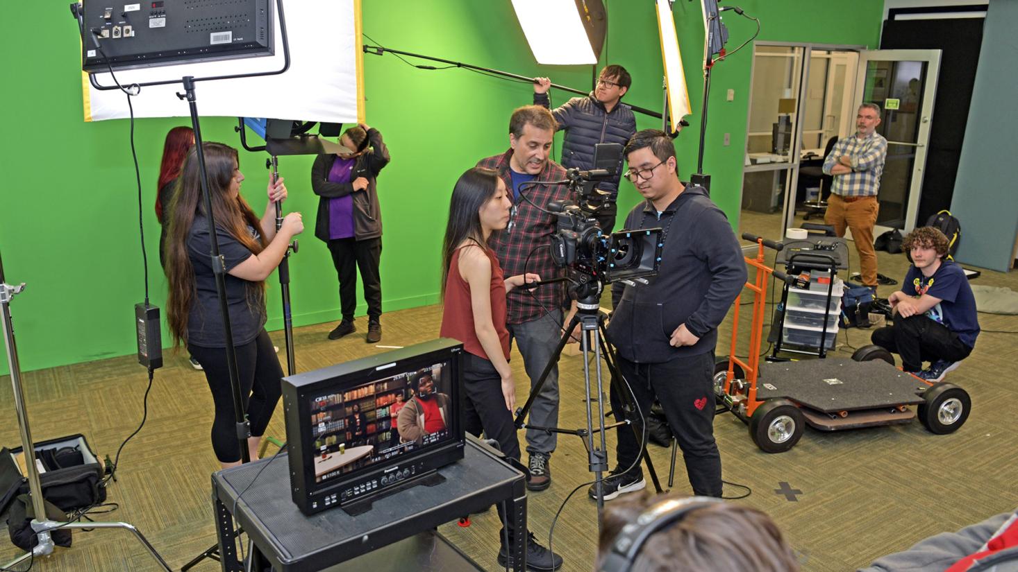 Students and professor looking at video camera