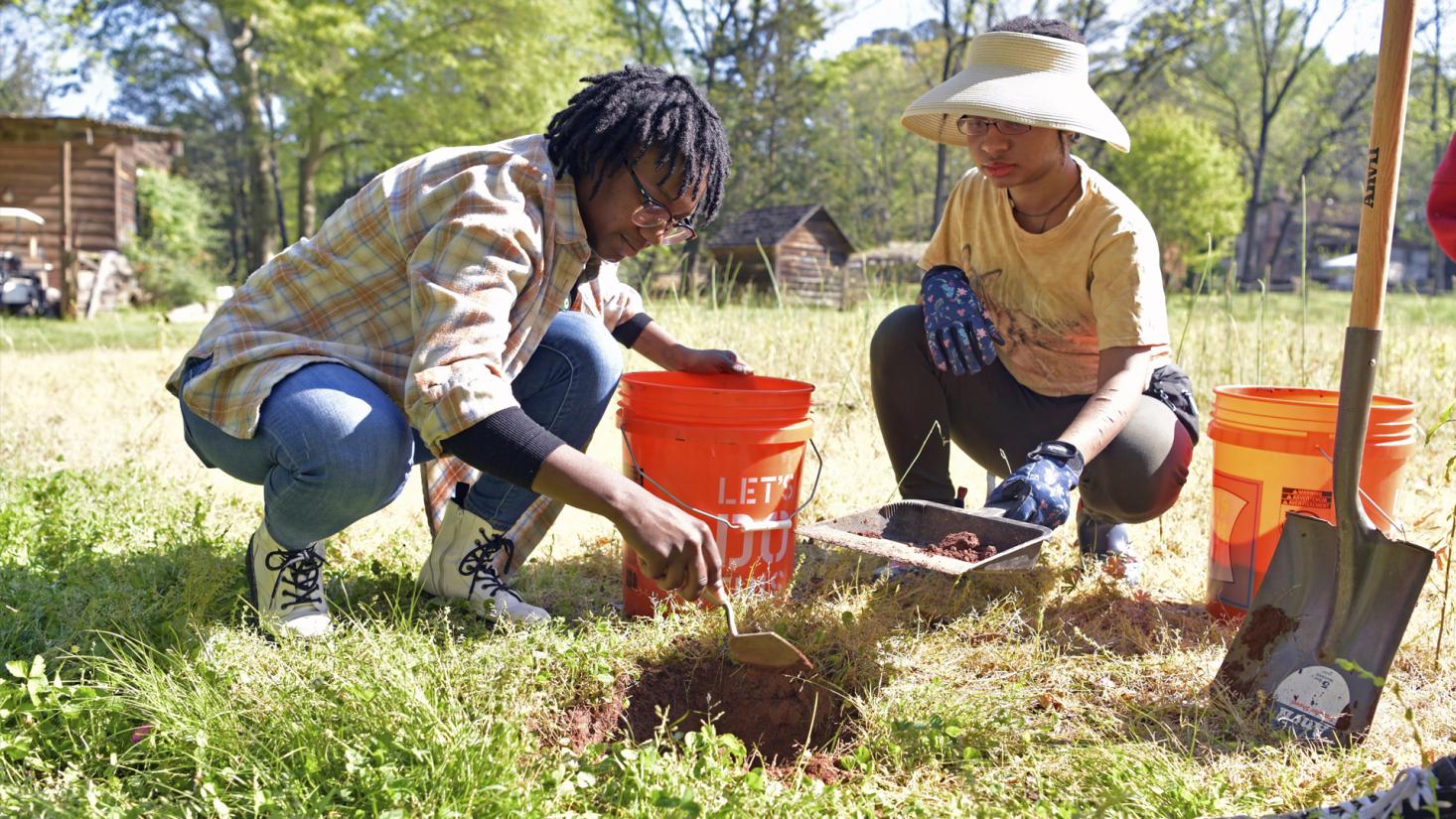 Two students digging a hole
