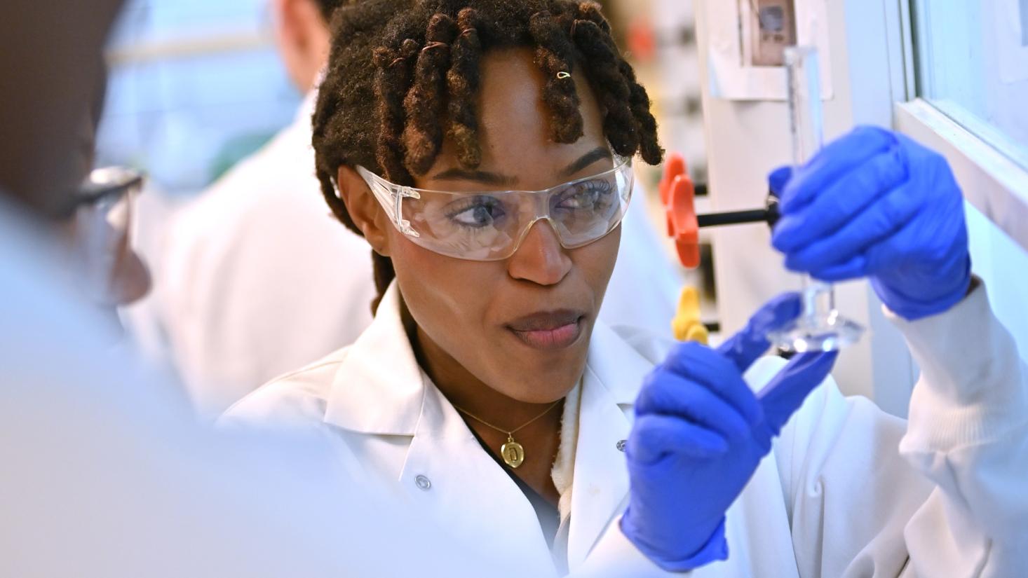 A female student looks at a test tube