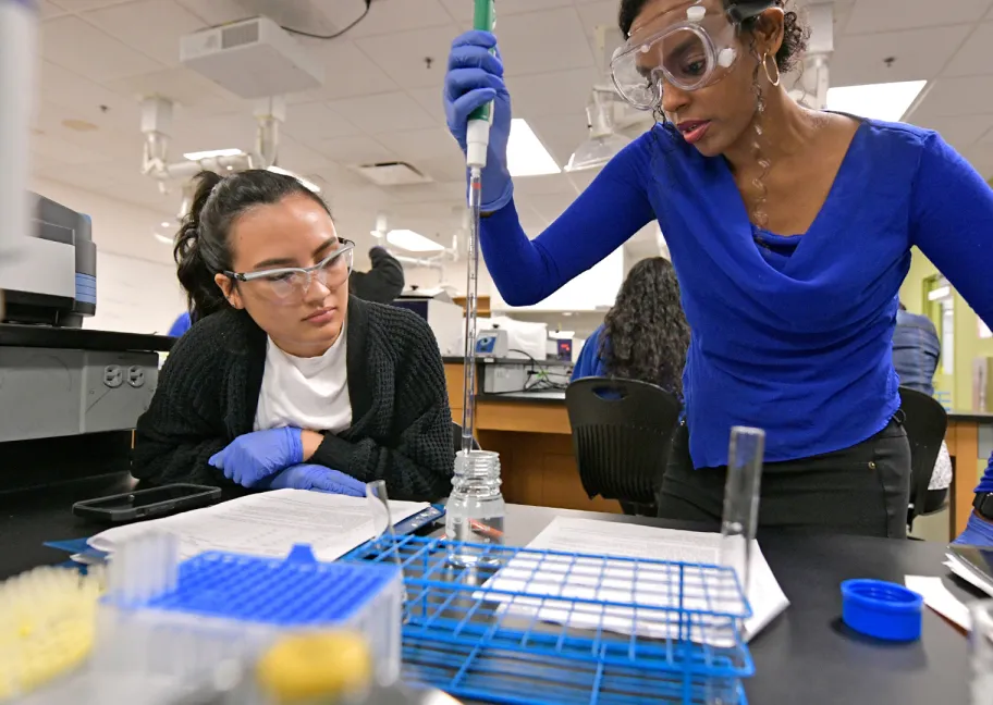 Two female students putting water in a bottle