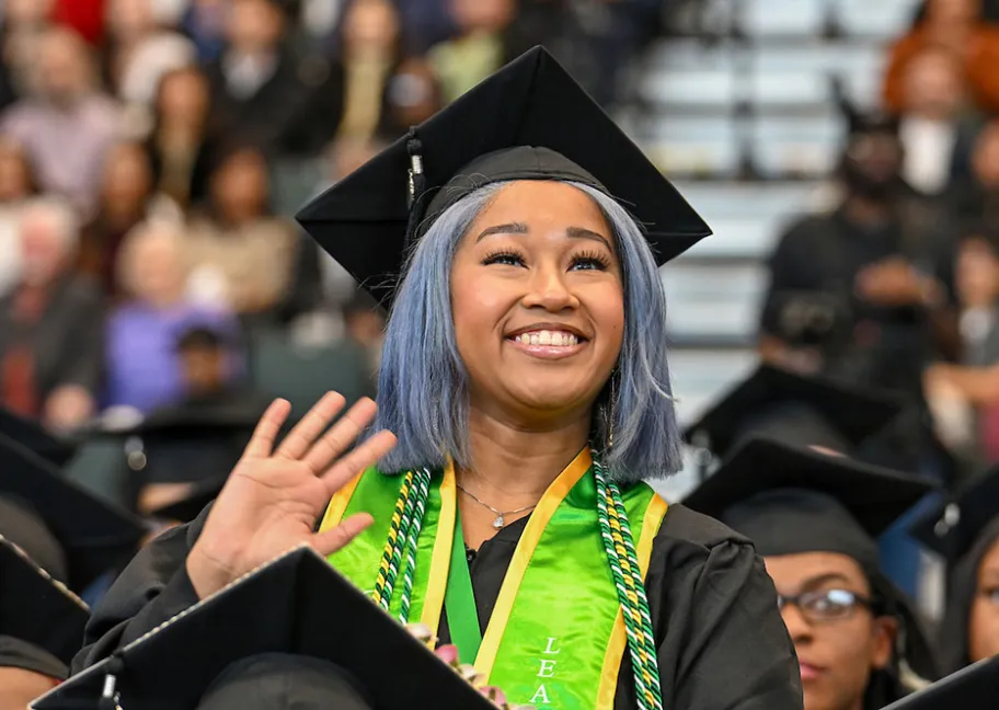 female GGC grad waving to family