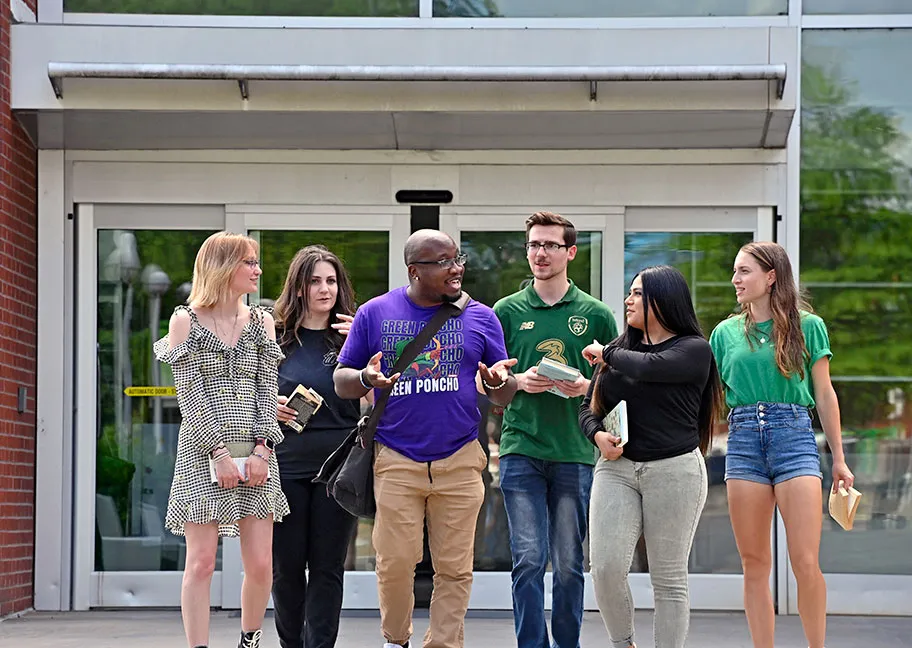 English faculty member walking and talking with students