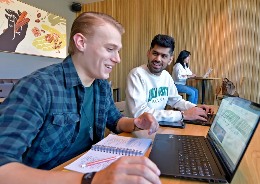 Three students looking at a laptop