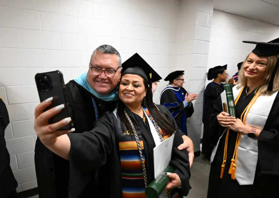 Dr. Matthew Bogan, (left) professor of special education and special education and social foundations chair in the School of Education, poses with the school’s graduates during the May 2025 commencement ceremony. 