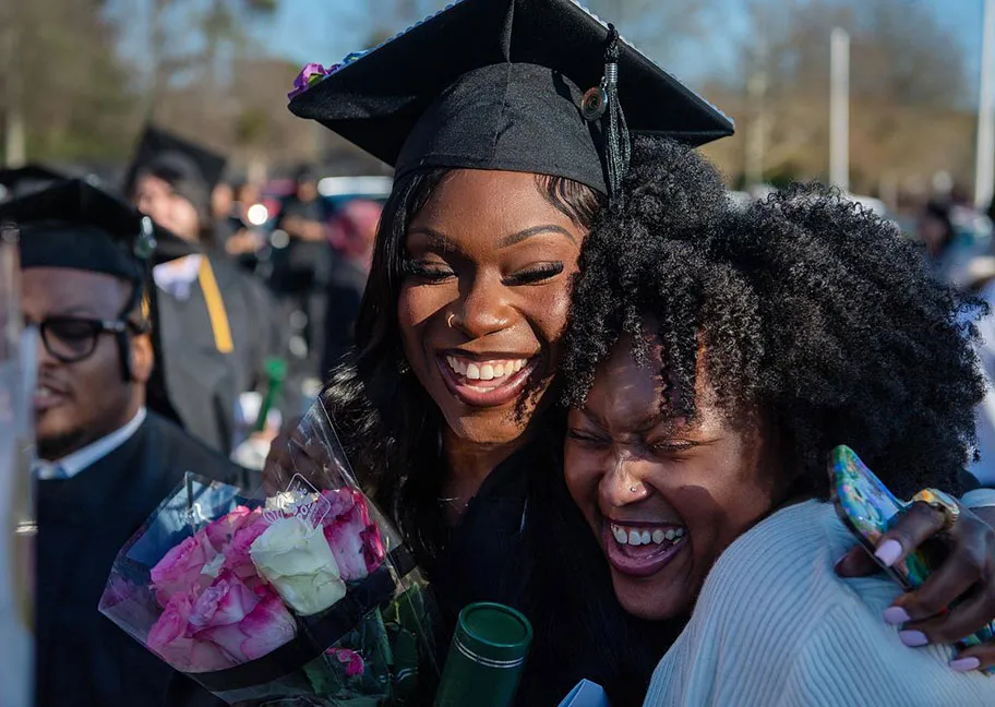 grad gets heartfelt hug from family member after graduation