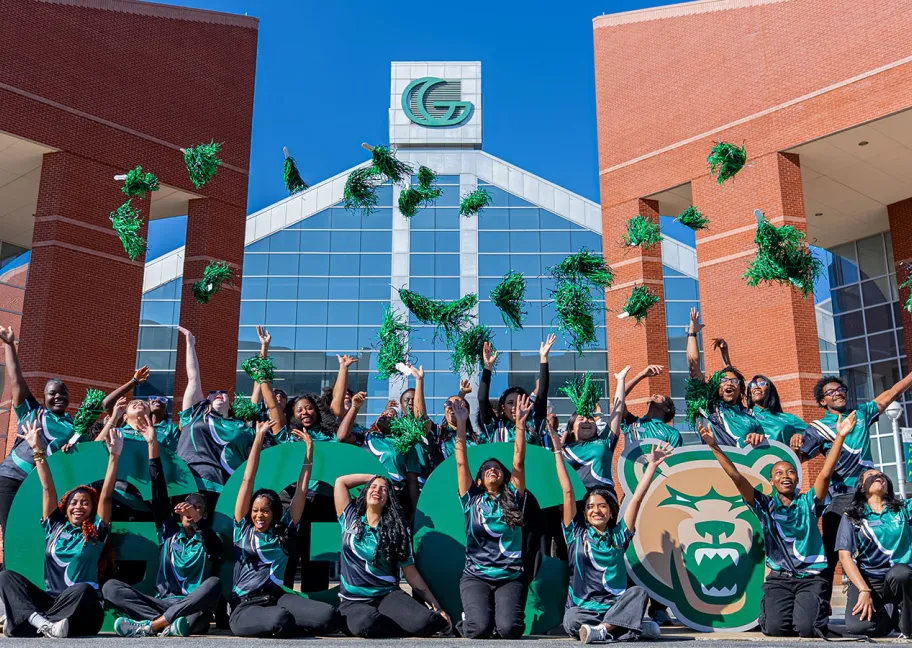 Group of student orientation leaders cheering and throwing up pompoms
