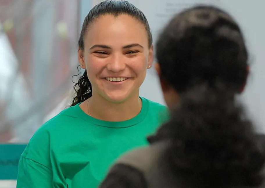 Josie Nunez smiles warmly as she assists with registration during the Olifer Math Competition
