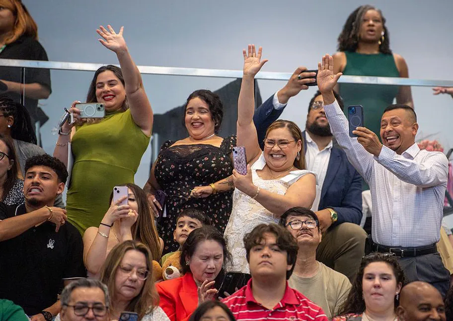 Cheering, waving family members in audience at commencement